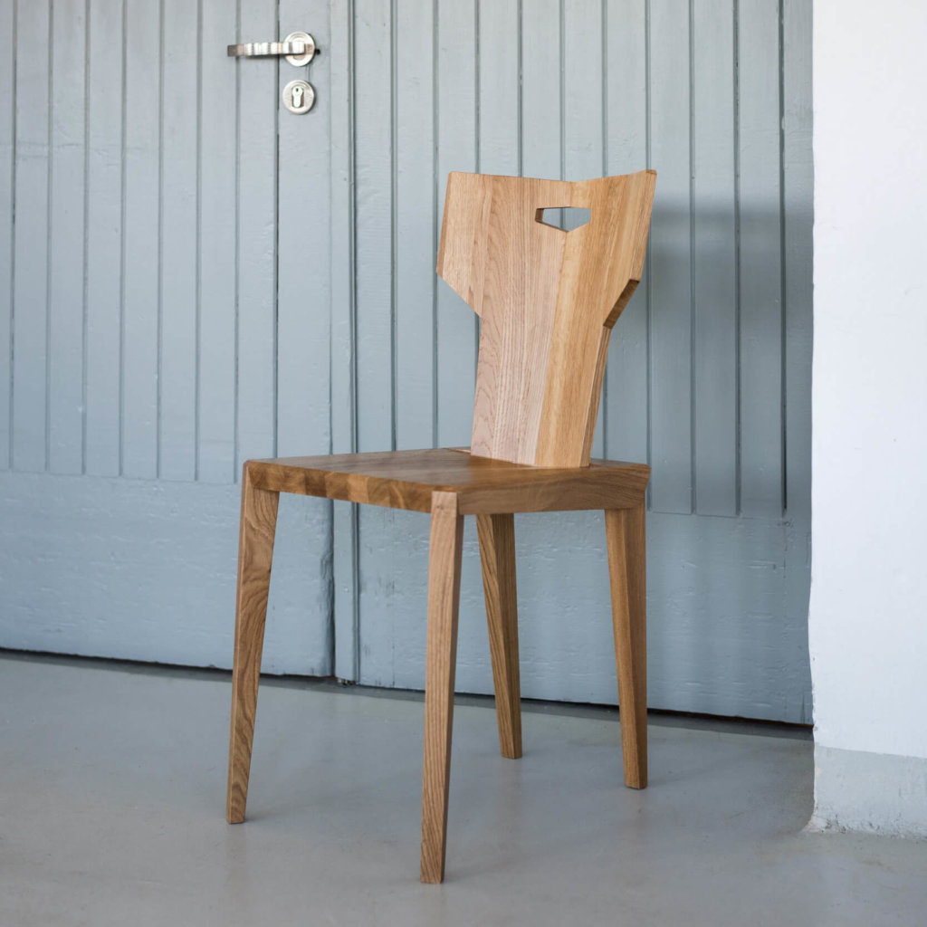 Dębowe krzesło Pegaz z uchwytem w kształcie litery T nawiązuje do zydla, polskie wzornictwo